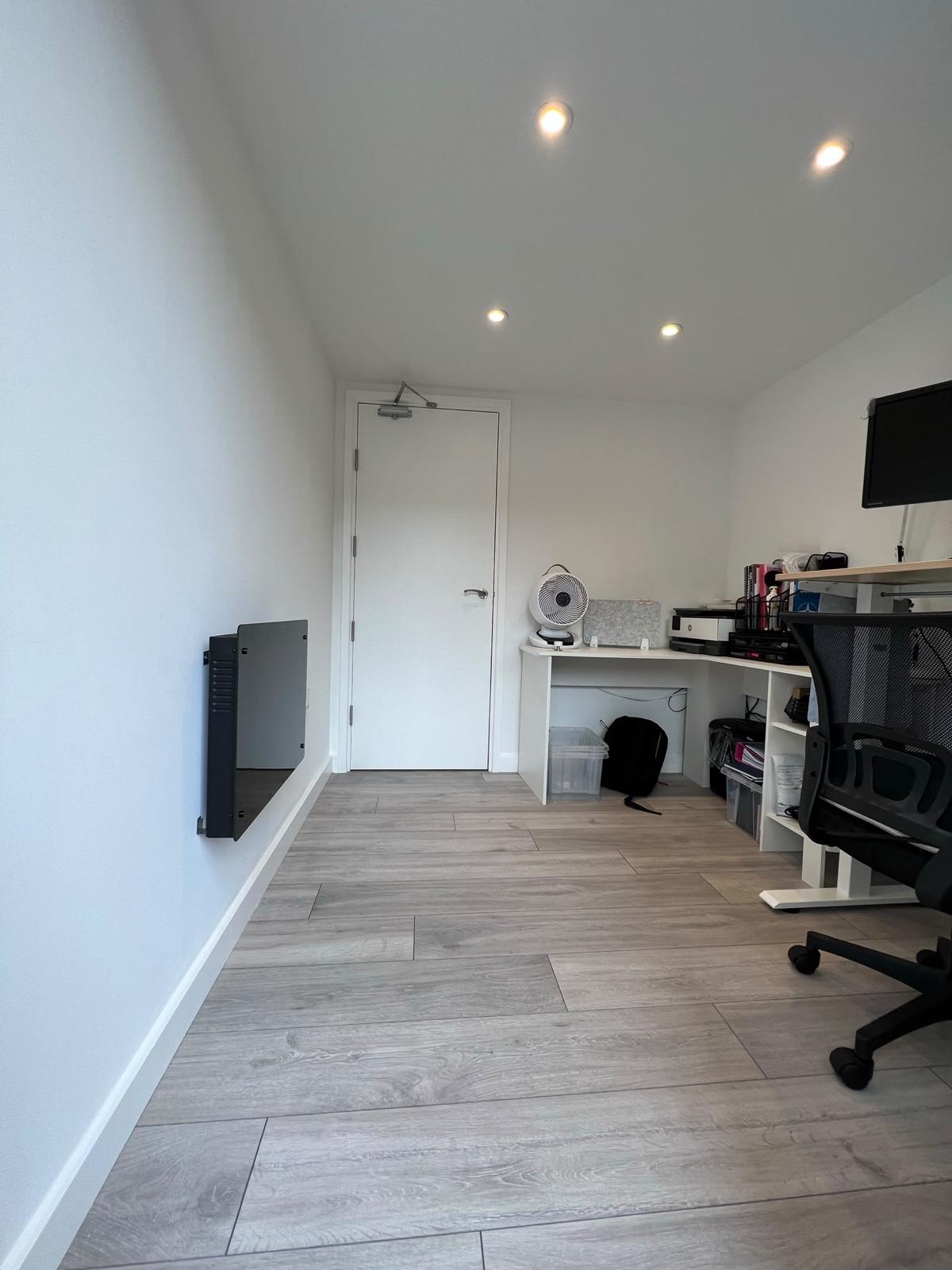 Home office with a fitted desk and recessed lighting