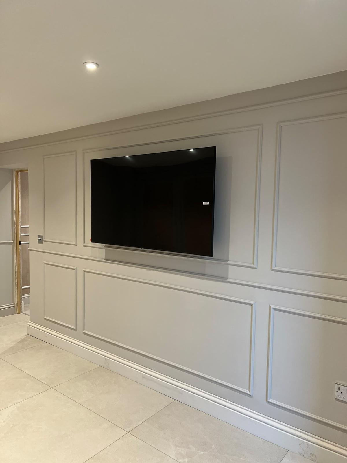 Panelled interior wall with a mounted television